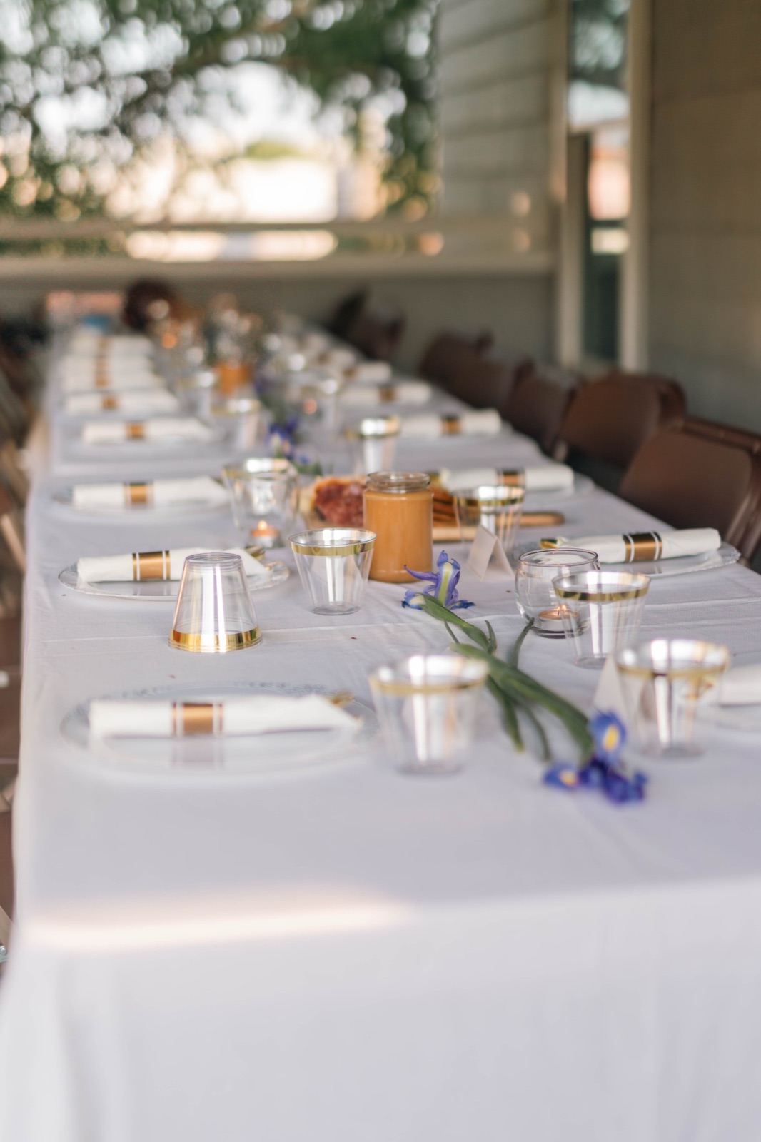 A long reception table set under lights at dusk